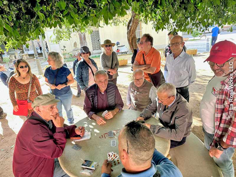 In the squares, men often play Sicilian card games.